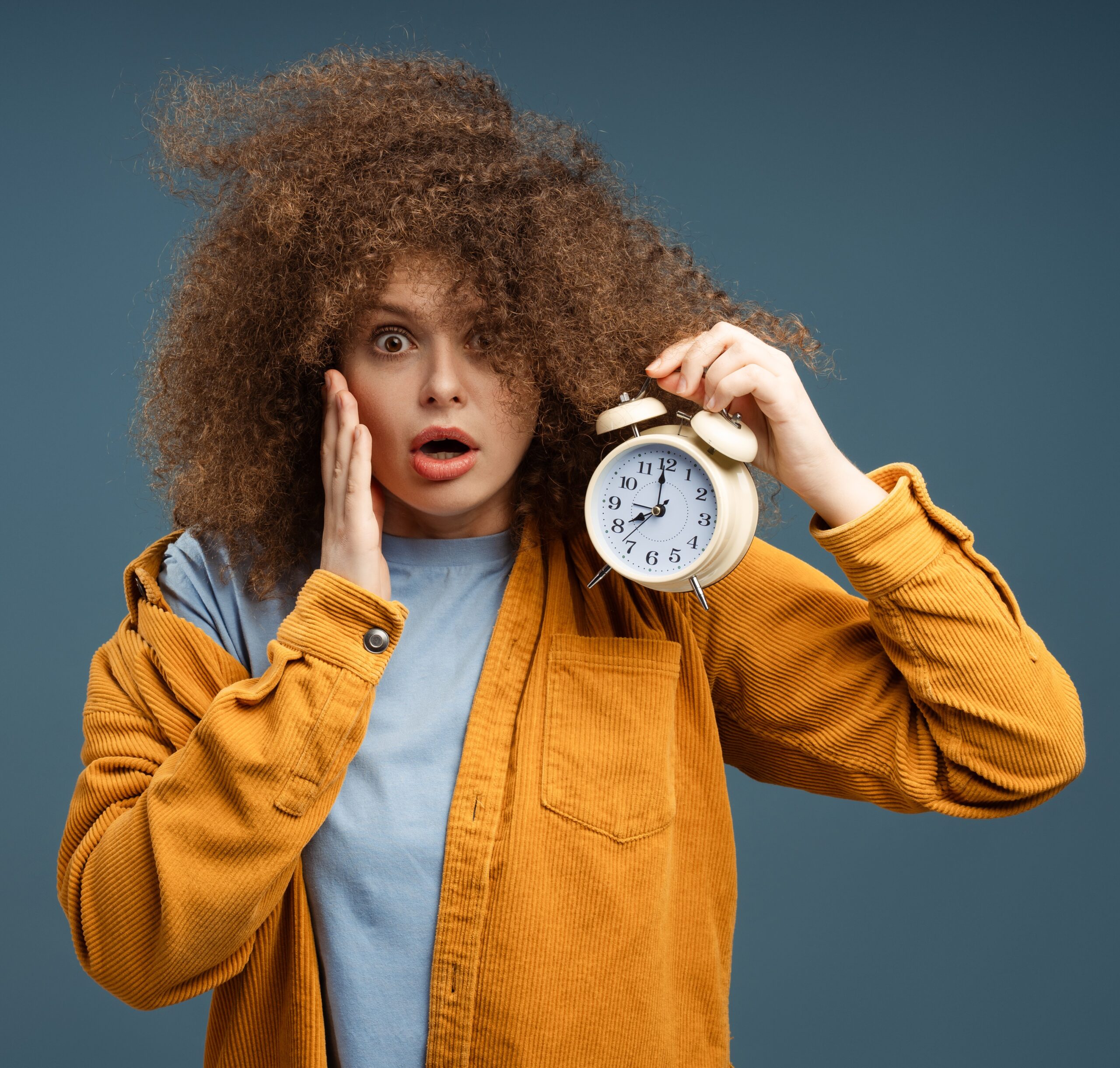 woman holding clock, worried about time running out